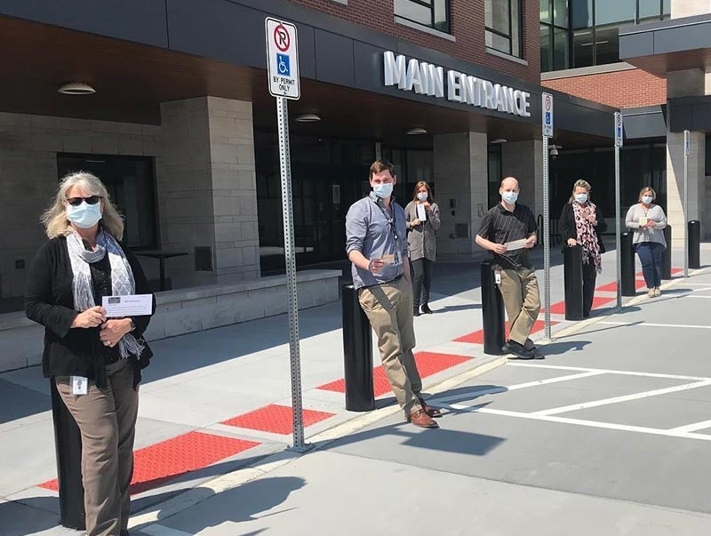 The Information Communication and Automation Technology (ICAT) Department pose outside the New Groves Hospital with their “Helping Hungry Heroes” gift cards, as they prepared the new facility for occupancy (April 2020)