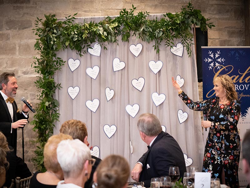 Co-Emcees, Dr. Doug Roach & Barbara Evoy, present the “Fund a Need” Auction items. Guests were asked to pledge to purchase a piece of vital equipment to outfit the New Groves Hospital